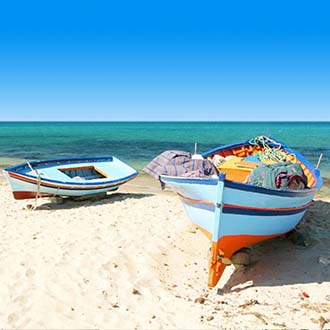 Strand met zee en bootjes Tunesie